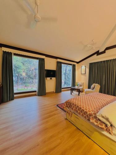 Un dormitorio con una cama y suelo de madera. en Yog Niketan Villa, en Rishīkesh