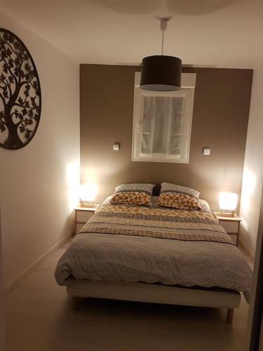 - une chambre avec un lit avec deux lampes et une horloge dans l'établissement Charmante petite maison de ville, à Calais