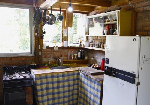 a kitchen with a white refrigerator and a stove at Refugio Pachalquimia in San Carlos de Bariloche