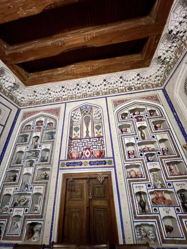 a room with a ceiling with paintings on it at Arabon Guest House in Bukhara
