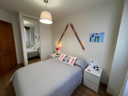 Dormitorio pequeño con cama y espejo en Precioso apartamento en San Isidro , ski , snow, en San Isidro