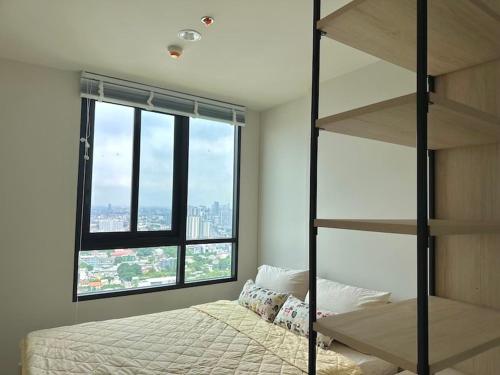 a bedroom with a bunk bed and a large window at N Condominium in Ban Bang Khen (1)
