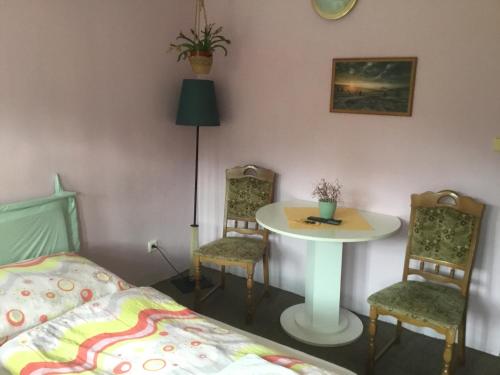 a bedroom with a bed and a table and chairs at Penzion Real in Bedřichov