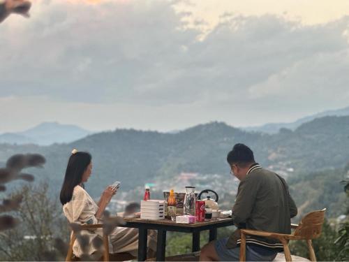 a man and a woman sitting at a table at Arabica Lodge (อาราบิก้า ลอดจ์) in Ban Huai Khai