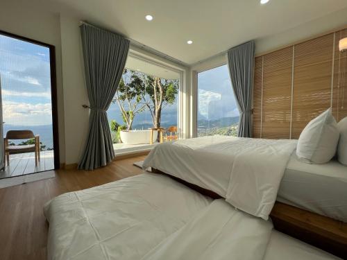 a bedroom with a large bed and a large window at Arabica Lodge (อาราบิก้า ลอดจ์) in Ban Huai Khai