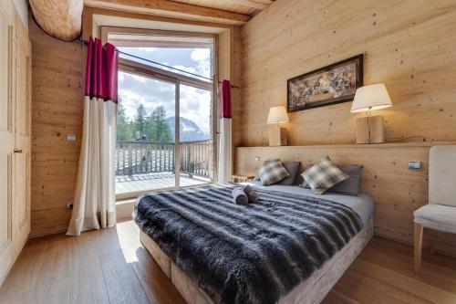 - une chambre avec un lit et une grande fenêtre dans l'établissement CHALET AROLAY, à Le Fornet