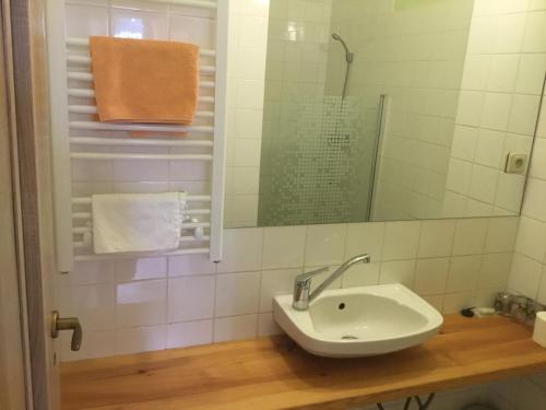 a white bathroom with a sink and a mirror at Penzion Real in Bedřichov