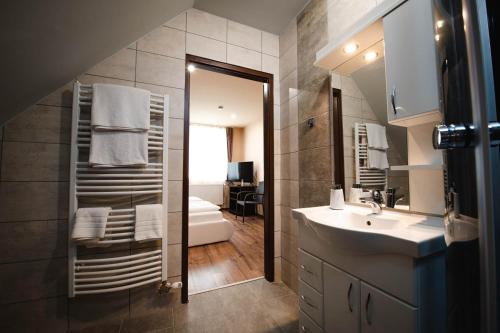 a bathroom with a sink and a mirror at Vidéki vendégház a Bükkben, pezsgőfürdővel. in Királd
