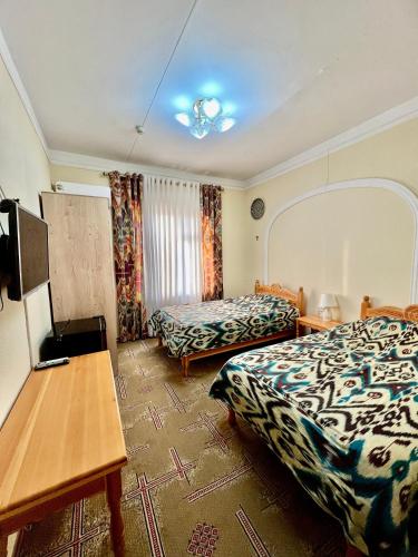 a hotel room with a bed and a table at Arabon Hotel in Bukhara