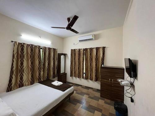um quarto com uma cama e uma ventoinha de tecto em Happy Vibes Resort em Nagaon