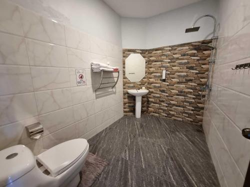 La salle de bains est pourvue de toilettes et d'un lavabo. dans l'établissement Bua Daeng Homestay Resort, à Amphoe Kumphawapi