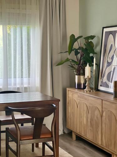 a dining room table with a potted plant on top of a cabinet at House with garden and parking 15 min to City Center in Edinburgh