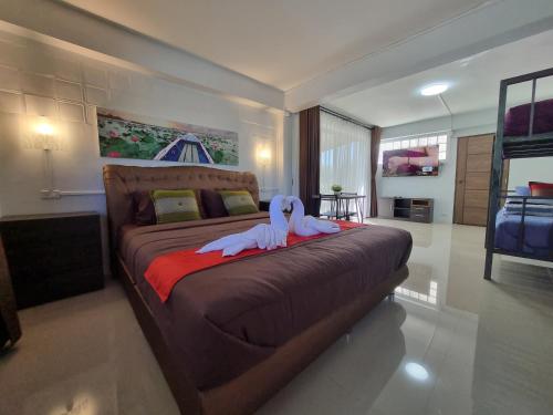 a bedroom with a bed with two swans on it at Bua Daeng Homestay Resort in Amphoe Kumphawapi