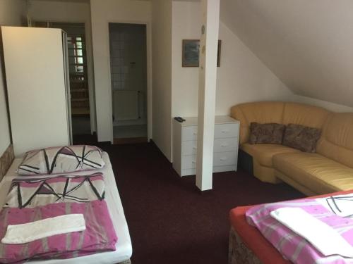 a living room with a couch and a bed and a table at Penzion Real in Bedřichov
