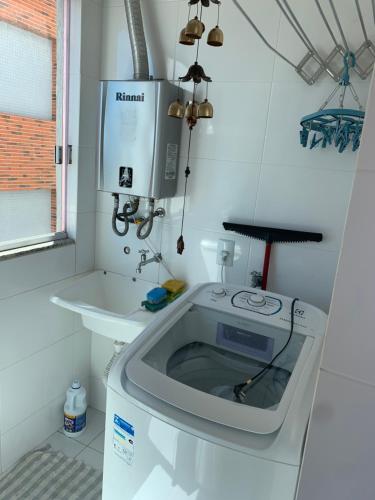 a washing machine in a bathroom with a sink at BORBOLETAS DO MAR in Bombinhas