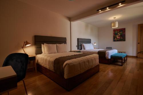 a hotel room with two beds and a desk at Las Privadas / Casa X By Nardazul in Oaxaca City