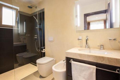 a bathroom with a sink and a toilet and a mirror at Villa Tilia in Kras