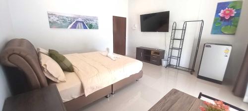 a bedroom with a bed and a television in it at Bua Daeng Homestay Resort in Amphoe Kumphawapi