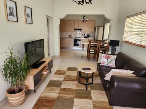 a living room with a couch and a tv at Eros Weg Family Flat in Windhoek