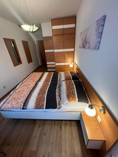 a large bed in a room with a wooden floor at Pension Strasser in Bad Schallerbach