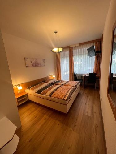 a bedroom with a bed and a table in a room at Pension Strasser in Bad Schallerbach