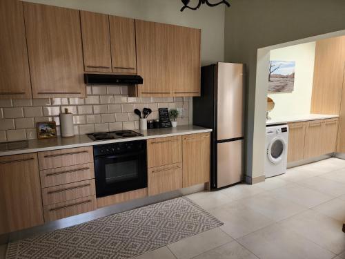 a kitchen with wooden cabinets and a refrigerator at Eros Weg Family Flat in Windhoek