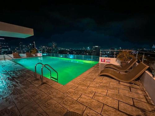 uma piscina no topo de um edifício à noite em Chillhauz Staycation Cebu em Cebu