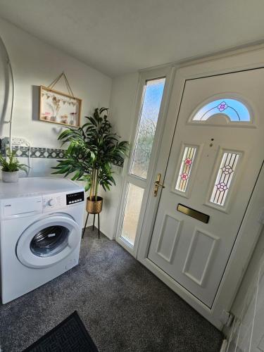 a laundry room with a washing machine and a door at Large Stylish 2 Bedroom Apartment Stevenage Sleep 6 in Stevenage