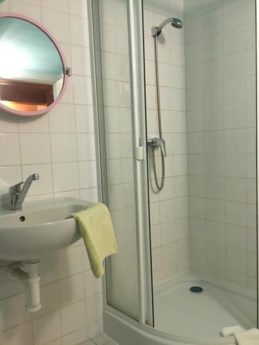 a bathroom with a shower and a sink and a mirror at Penzion Real in Bedřichov