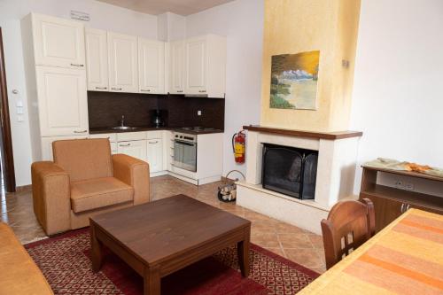 a kitchen with a living room with a fireplace at Ευήλιον Σουίτες in Elati