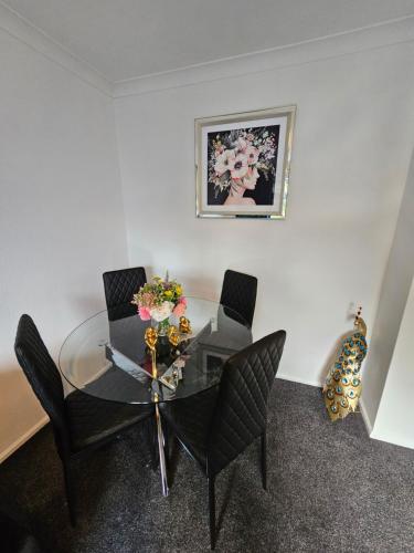 a dining room with a glass table and chairs at Large Stylish 2 Bedroom Apartment Stevenage Sleep 6 in Stevenage