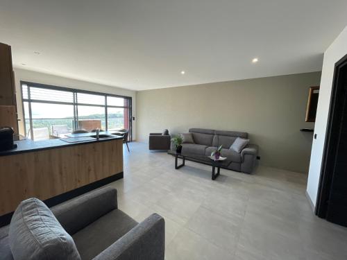 a living room with two couches and a table at Les Restanques du lac in La Chapelle