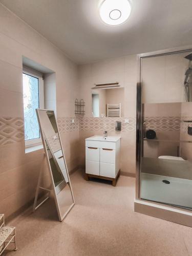 a bathroom with a shower and a sink and a mirror at Sztuka Smaku - Restauracja i Hotelik in Świdnica