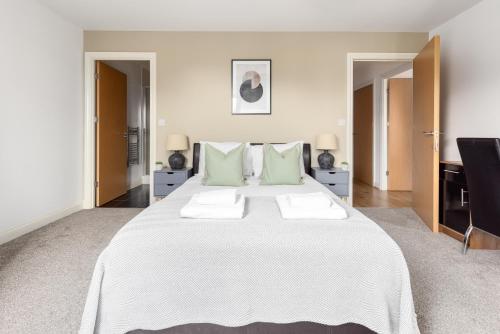 een slaapkamer met een groot wit bed met groene kussens bij The Colindale Collection in Colindale