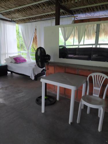 Camera con letto, tavolo e sedia di HOTEL GUATAQUI PUERTO PRINCIPAL a Guataquí