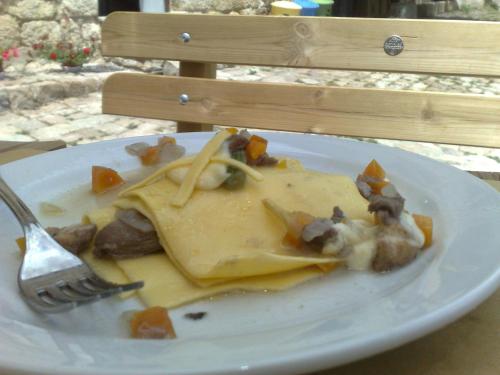 a plate of food on a table with a fork at La Locanda Di Cadì in Petralia Soprana