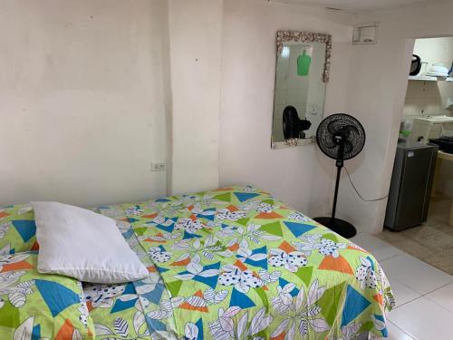 - une chambre avec un lit et une couette colorée dans l'établissement Habitación independiente cerca al mar., à Puerto Salgar