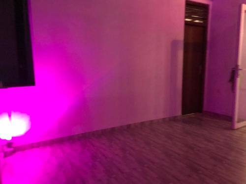 a room with a purple wall with a pink light at White Rooms by Sineth in Ratmalana