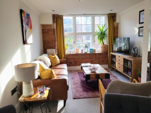 a living room with a couch and a tv at Cocoa River - Quiet city centre, close to the Shambles, on the river, two bed, two bath, allocated parking in York