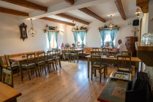 ein Restaurant mit Holztischen und Tischen in der Unterkunft Pension Kamenný Dvůr in Franzensbad