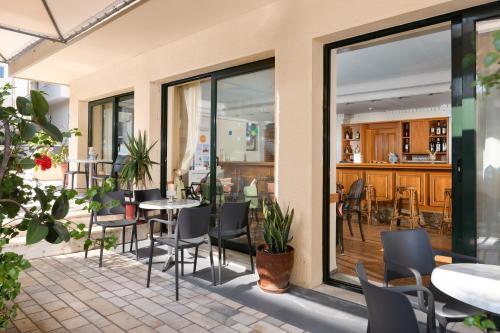un patio con tavoli e sedie in un ristorante di Nafsika Hotel a Città di Rodi