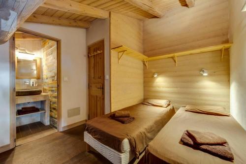 a bedroom with two beds in a wooden room at BONNE NEIGE in La Daille