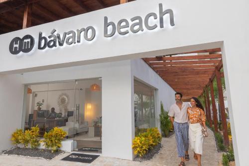 HM Bavaro Beach - Adults Only في بونتا كانا: رجل وامرأة يقفان أمام متجر