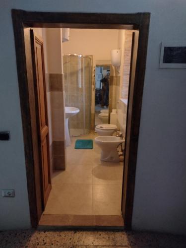 Habitación con vistas a un baño con 2 aseos y espejo. en Casa vacanze Borgo medievale, en Porzano