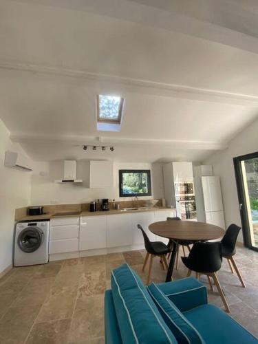 une cuisine avec une table et des chaises dans une pièce dans l'établissement Appartement de charme près d'Uzès, à Saint-Siffret