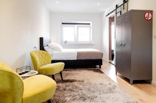 - une chambre avec un lit, un canapé et des chaises dans l'établissement M&M Studio's 1 & 2, à Zandvoort