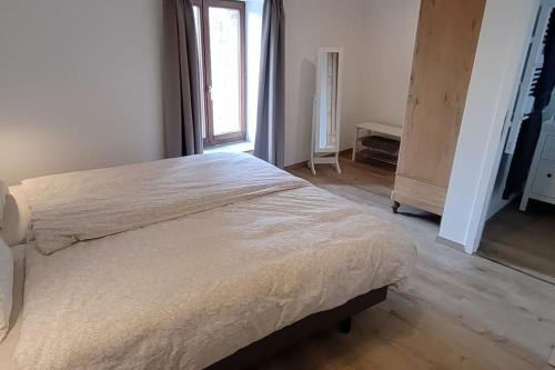 Cama grande en habitación blanca con ventana en Le 43, Gîte rural dans la vallée de la Sambre., en Merbes-le-Château