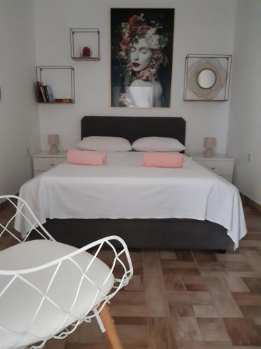 a bedroom with a large bed with a chair at Varaždinci in Rogoznica