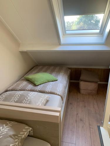 een klein bed in een kamer met een raam bij At MarRies in Wilp