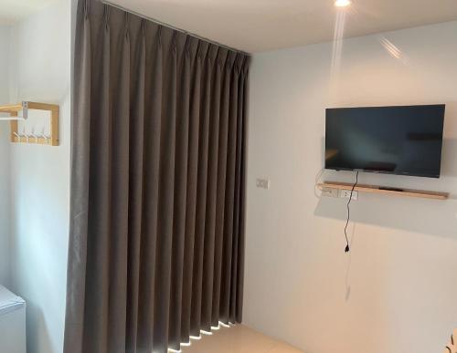 ein Wohnzimmer mit einem TV und einem Vorhang in der Unterkunft Pattaya inn hotel in Pattaya South